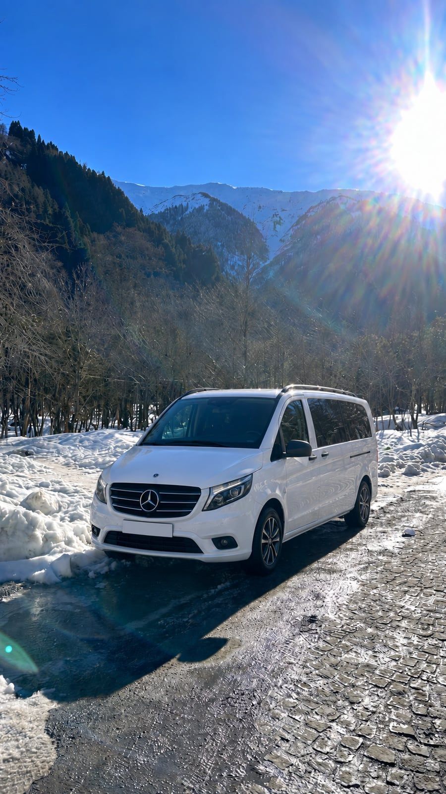 Karlı dağ yolunda beyaz Mercedes Vito